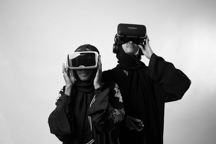 Women Using VR Headsets For Smartphones And Wireless Headphones