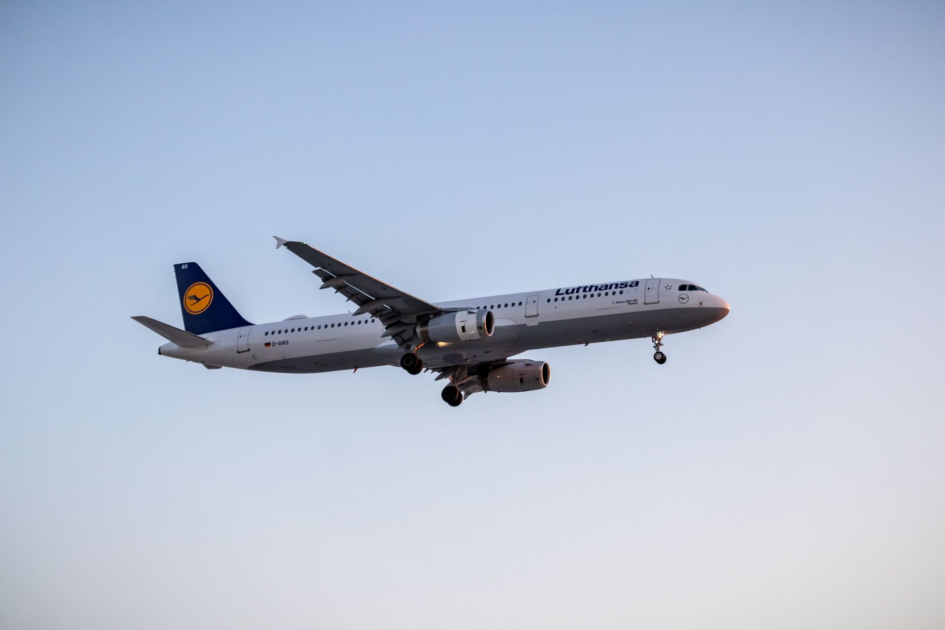 A Lufthansa aircraft flying at sunset against a clear sky, symbolizing modern air travel.