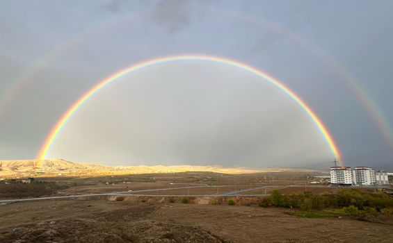 A double rainbow is seen over a field