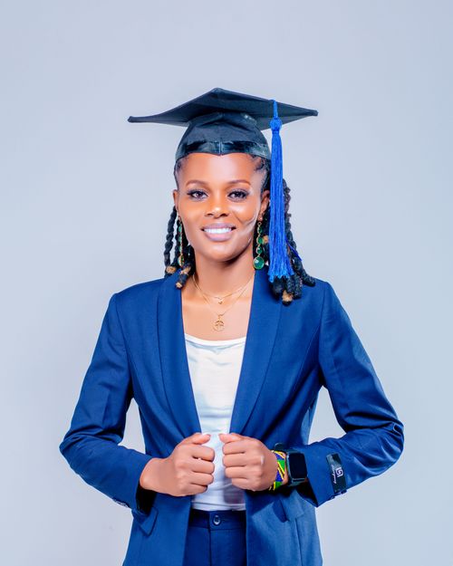 Free Smiling graduate in a cap and blue suit against a white background. Stock Photo