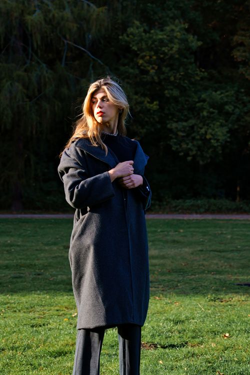 Free Fashionable woman poses with elegance in a Berlin park on a sunny day. Stock Photo