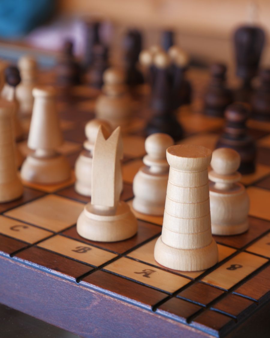 Chess pieces on a wooden board mid-game