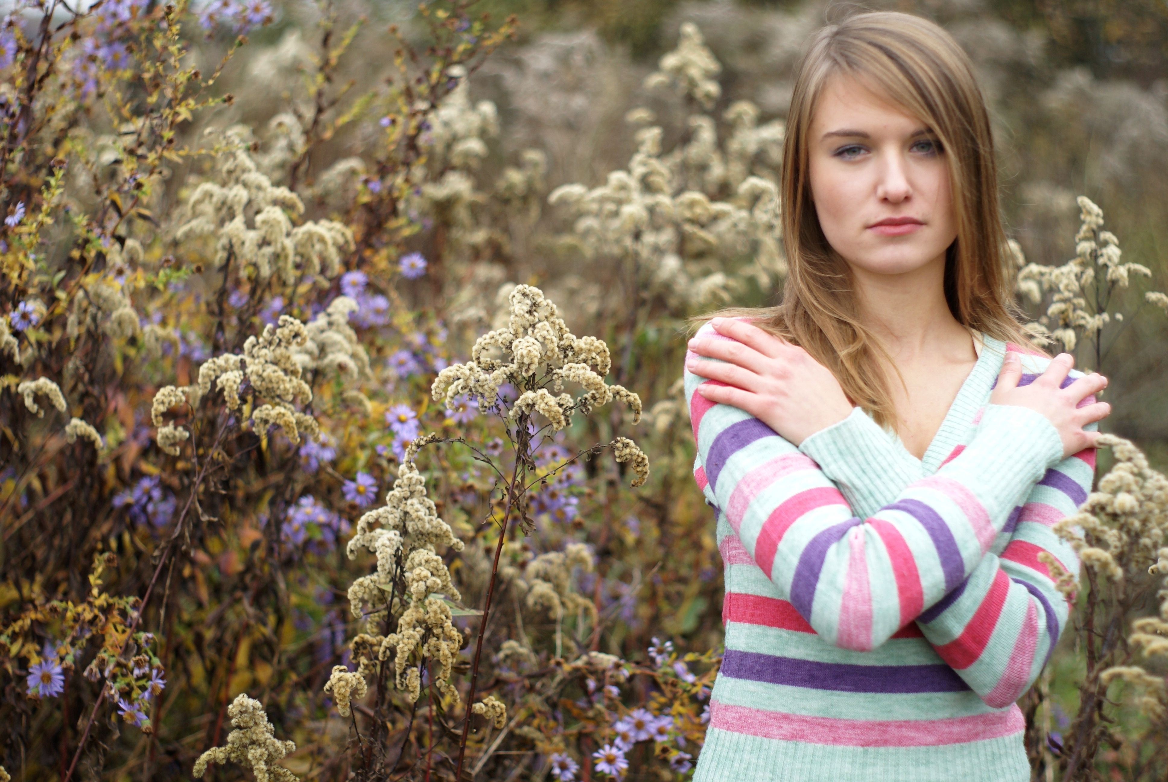 A woman standing in front of a field of flowers · Free Stock Photo