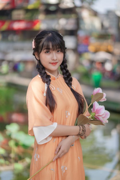 Young Woman in an Ao Dai Dress Holding a Bouquet of Lilies · Free Stock  Photo