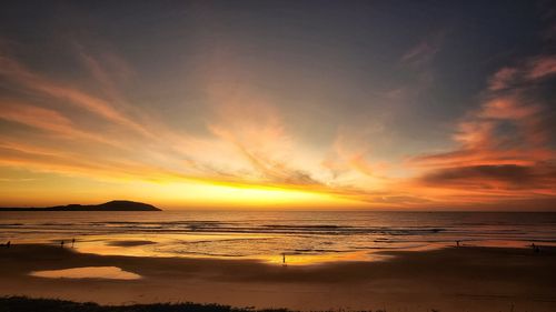 Free A mesmerizing sunset view over the beach with colorful skies and gentle waves reflecting the light. Stock Photo