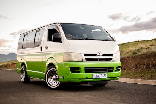 A colorful Toyota HiAce van on a scenic road, ideal for travel and transportation themes.