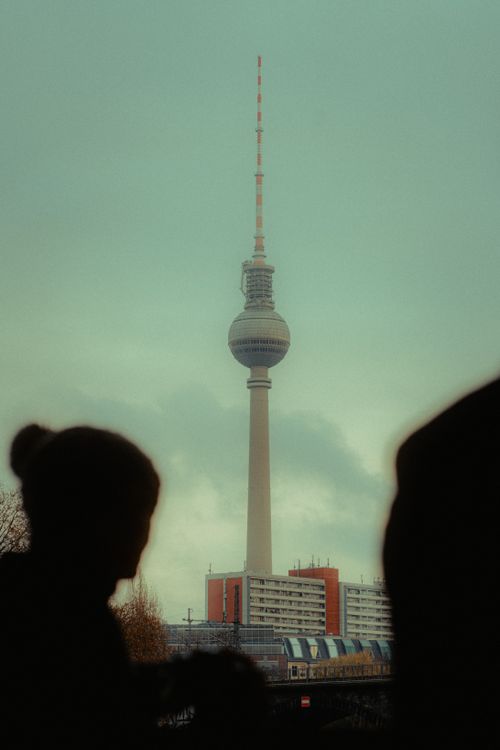Free Silhouettes of people in front of the iconic Berlin TV Tower under a moody sky. Stock Photo