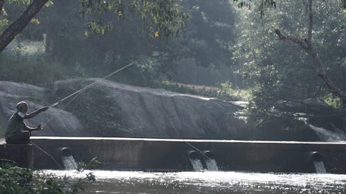 Elderly Fisherman Fishing in Reservoir