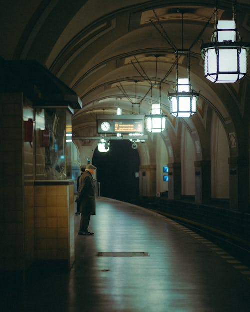 Senior Man Waiting at an Illuminated Subway Platform