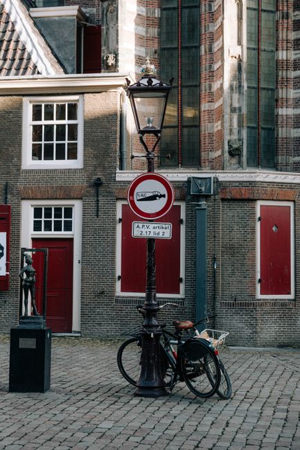 A classic Amsterdam scene with bicycles near a brick building, showcasing urban charm.