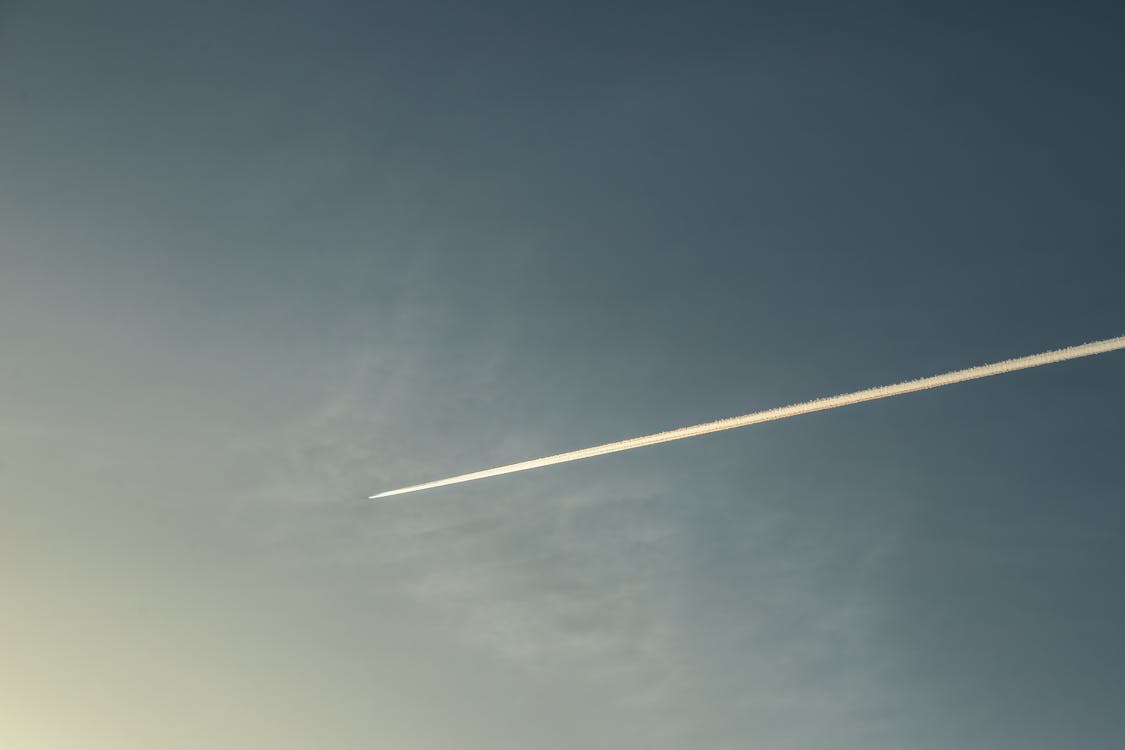 An Airplane Leaving Contrails in Blue Sky 
