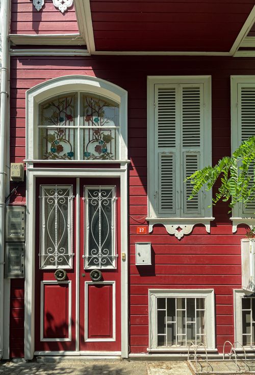 Free Elegant red facade in Istanbul featuring ornate double doors and traditional details under daylight. Stock Photo