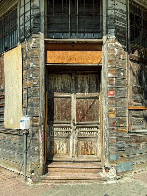 Free Old wooden doorway in İstanbul with vintage charm under the sunlit urban scene. Stock Photo