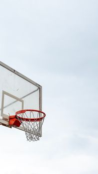 A basketball hoop with a net against a bright, clear sky captures the essence of outdoor sports.