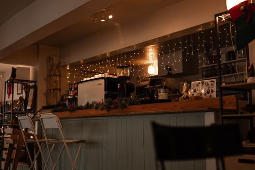 Warm and inviting café scene with festive lights and coffee equipment on display.
