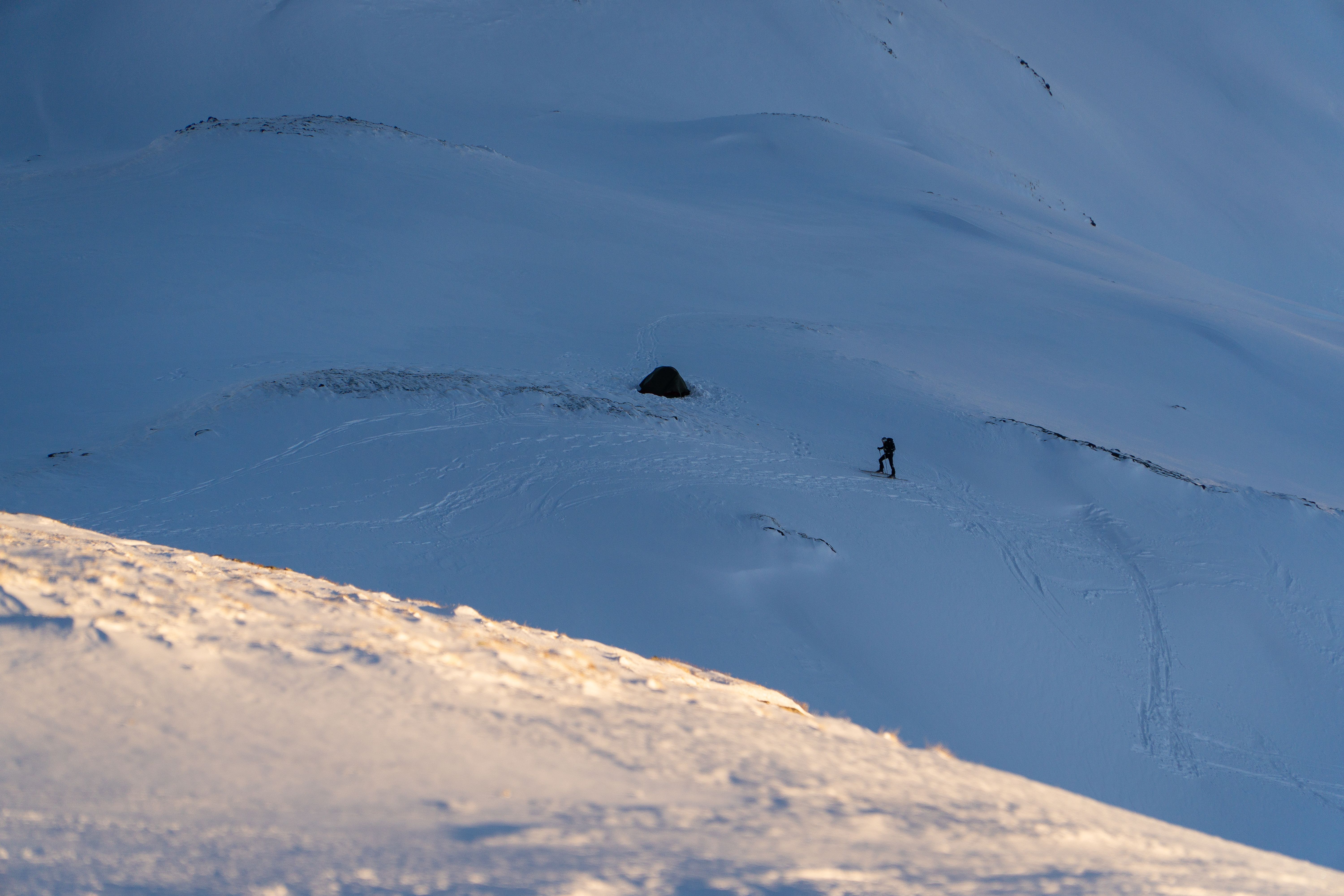 A skier performs a thrilling jump off a snowy mountainside, showcasing extreme winter sports.