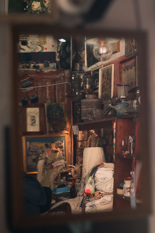 Free Warm and cluttered interior reflection showcasing artwork and cozy decor. Stock Photo