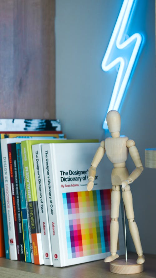 Books by Wooden Figurine on Shelf