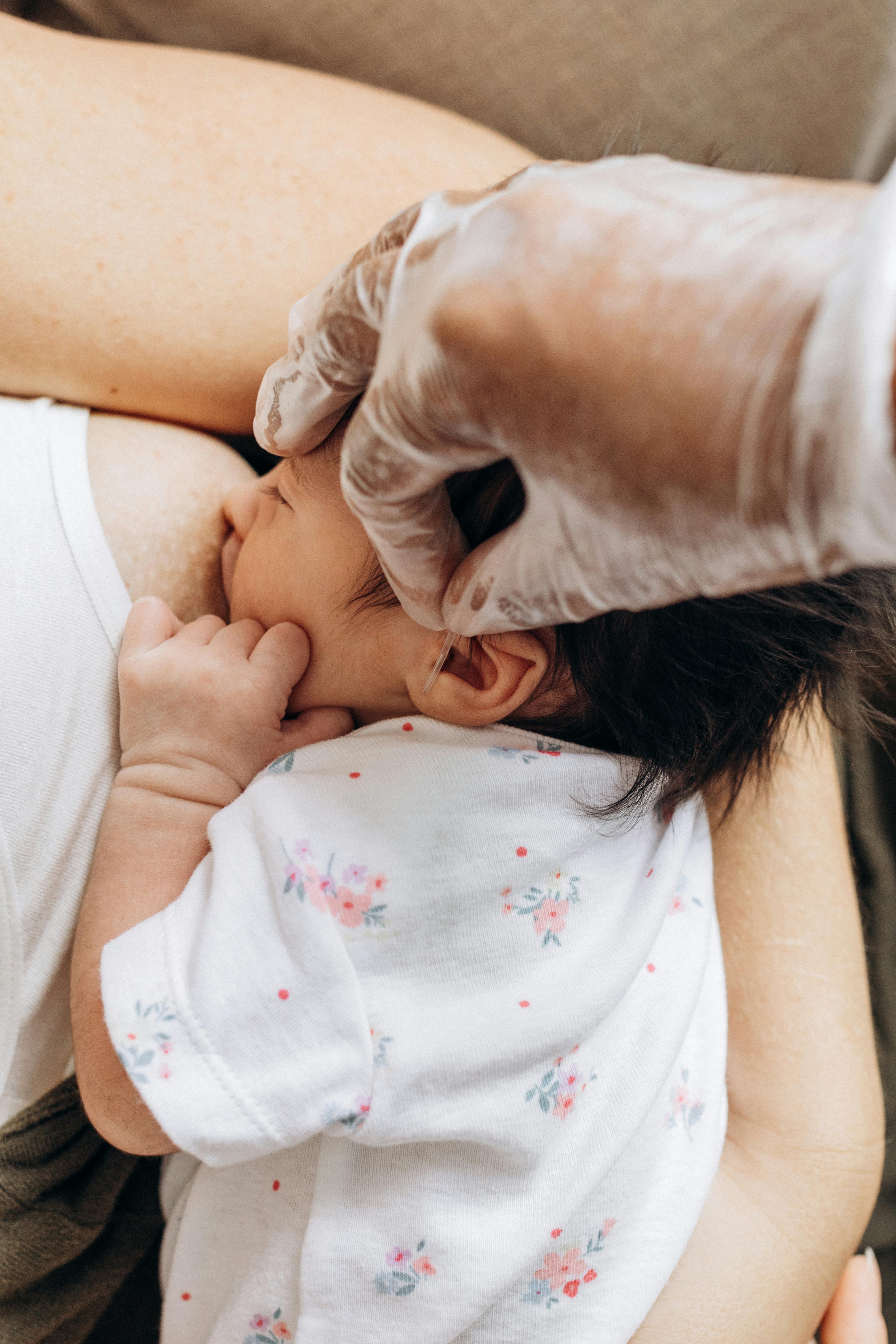 a woman is holding a baby while another person is holding her hand