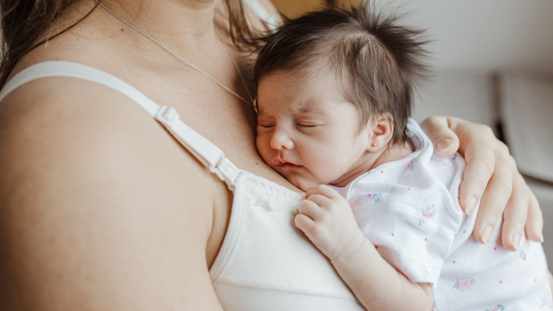 Modafinil Safety While Breastfeeding: A Comprehensive Guide A mother holds her sleeping newborn close, showcasing love and bonding indoors — modafinil safety while breastfeeding