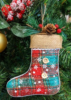 Colorful plaid stocking ornament with buttons on a decorated Christmas tree.
