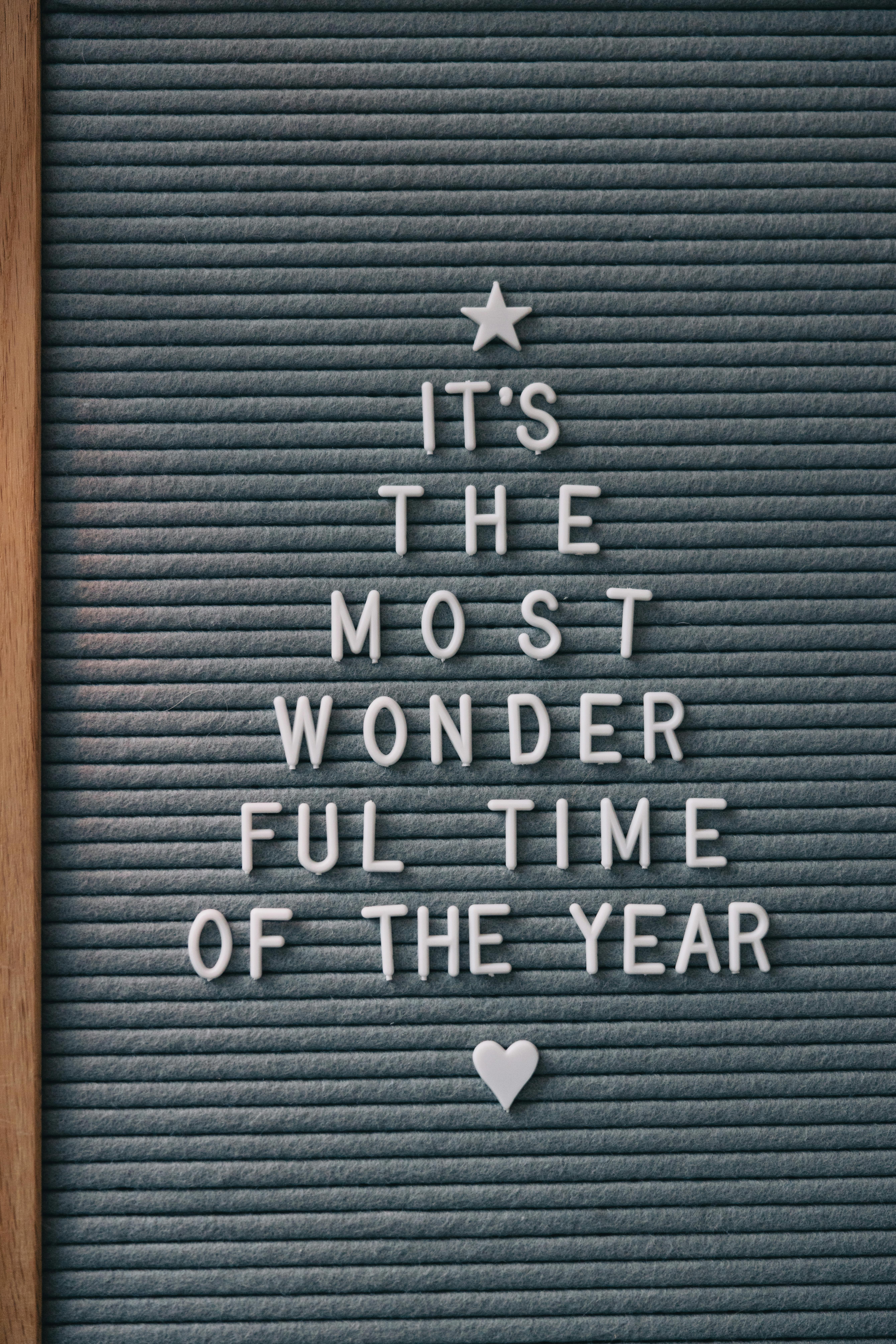 A styled letterboard featuring a festive Christmas message in a tree shape.