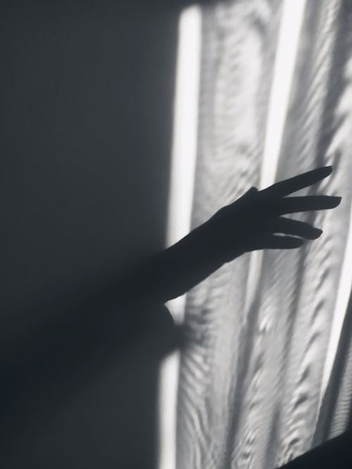 Womans Hand on the Window Curtain 