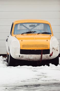 A classic yellow car parked in a snowy landscape in Jönköping, Sweden.