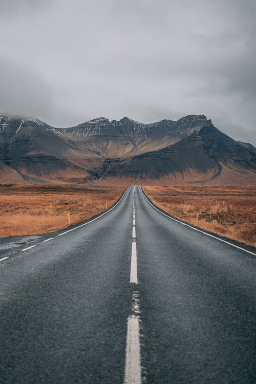Jalan Raya Kosong Menghadap Gunung Di Bawah Langit Gelap
