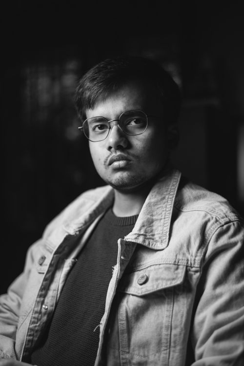 Free A serious man wearing a denim jacket and glasses in a black and white portrait. Stock Photo