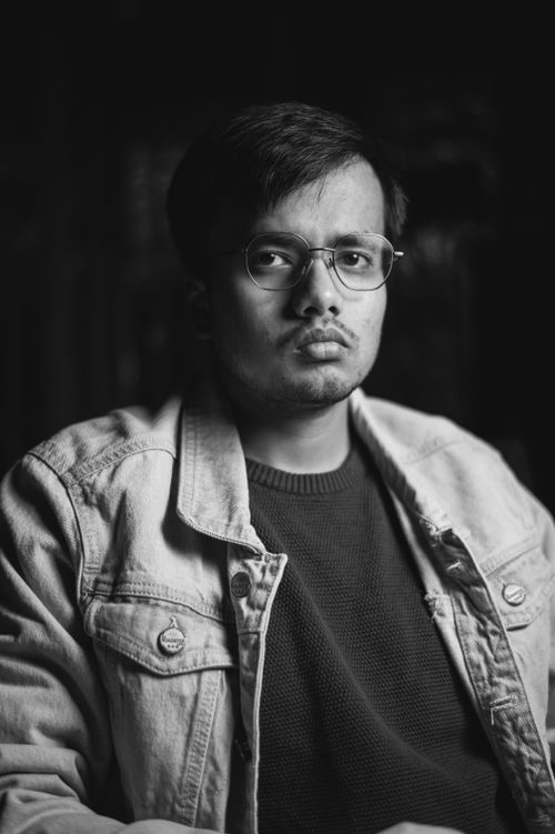 Free Black and white portrait of a man with eyeglasses and jean jacket, warm expression. Stock Photo