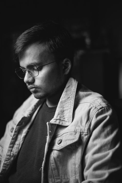 Free Monochrome portrait of a man wearing glasses and a denim jacket, exuding a serious mood. Stock Photo