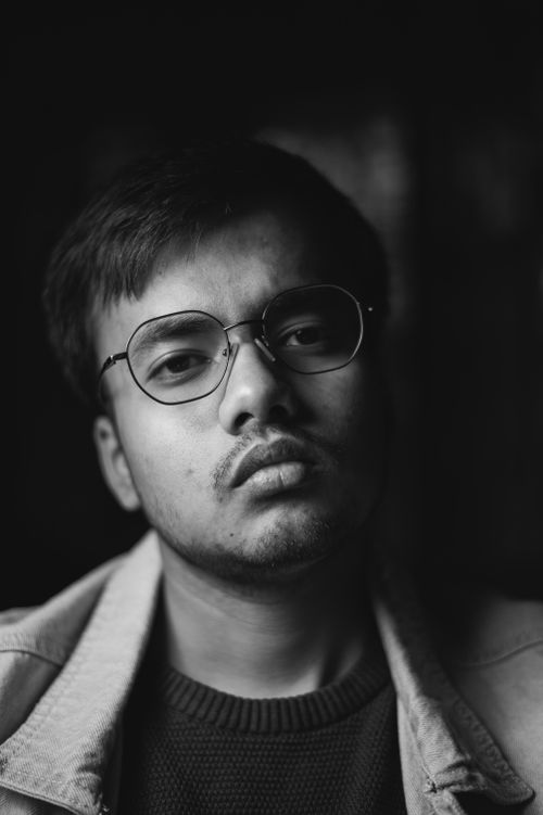 Free Black and white portrait of a man wearing eyeglasses and a denim jacket. Stock Photo