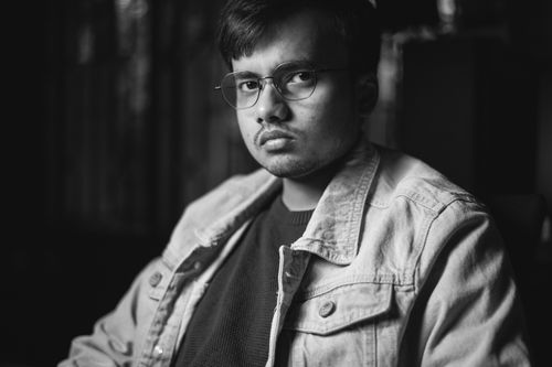 Free A monochrome portrait of a man in a denim jacket with eyeglasses. Stock Photo