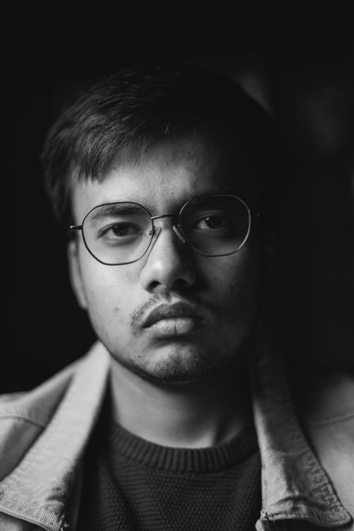 Free Monochrome portrait of a man with eyeglasses and denim jacket, serious expression. Stock Photo