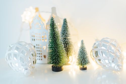 Free Christmas ornaments and miniature trees with festive lights create a cozy winter ambiance. Stock Photo