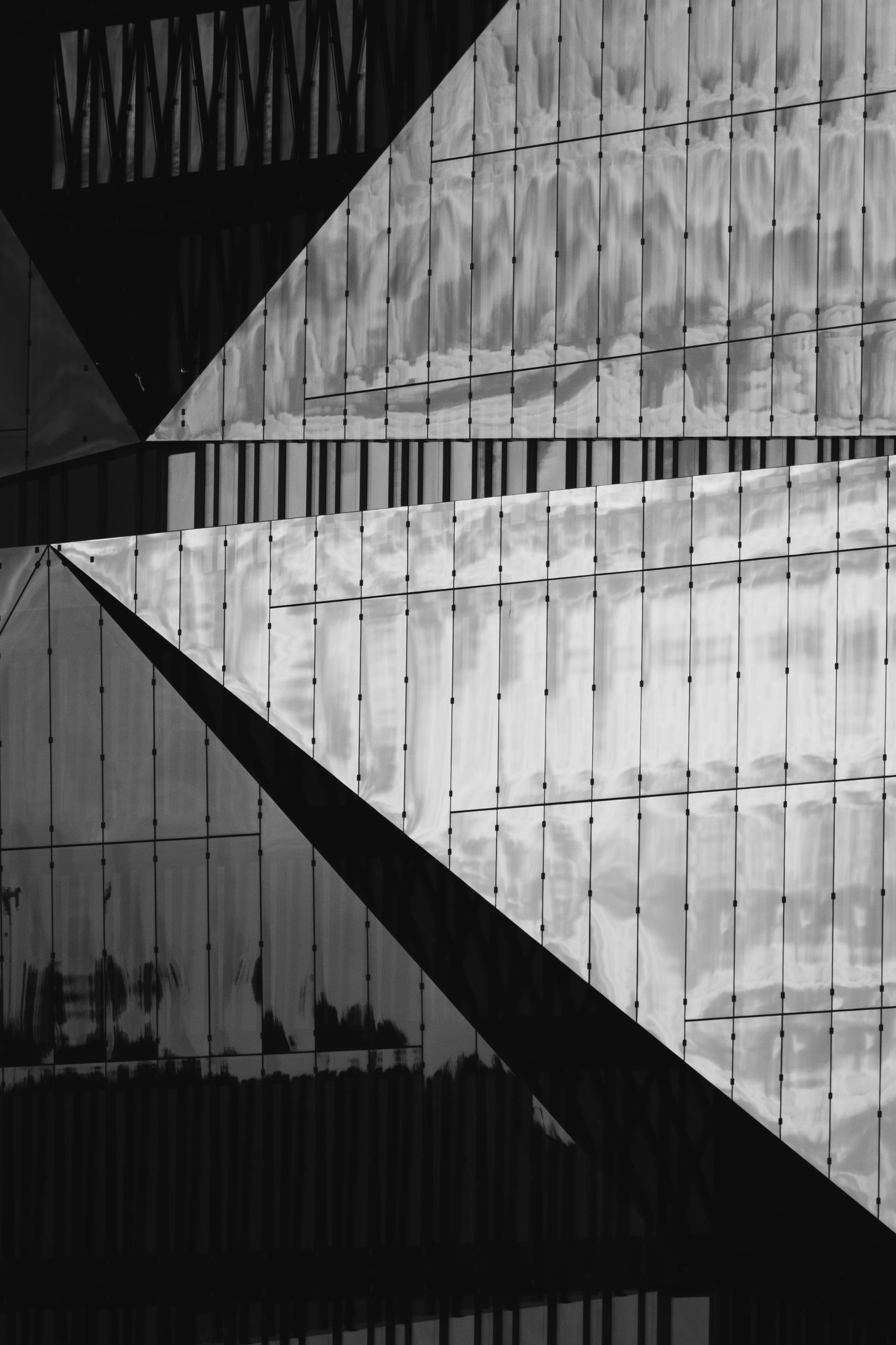 Black and white abstract view of a modern building facade with geometric patterns.