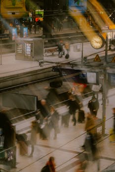 Blurred motion of commuters at a modern urban railway station, capturing the city's hustle and bustle.
