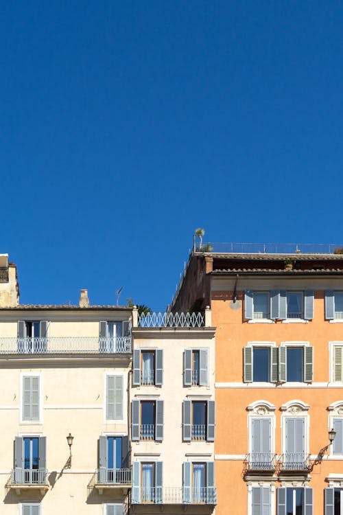 Facades of Residential Buildings with Window Shutters under Blue Sky 