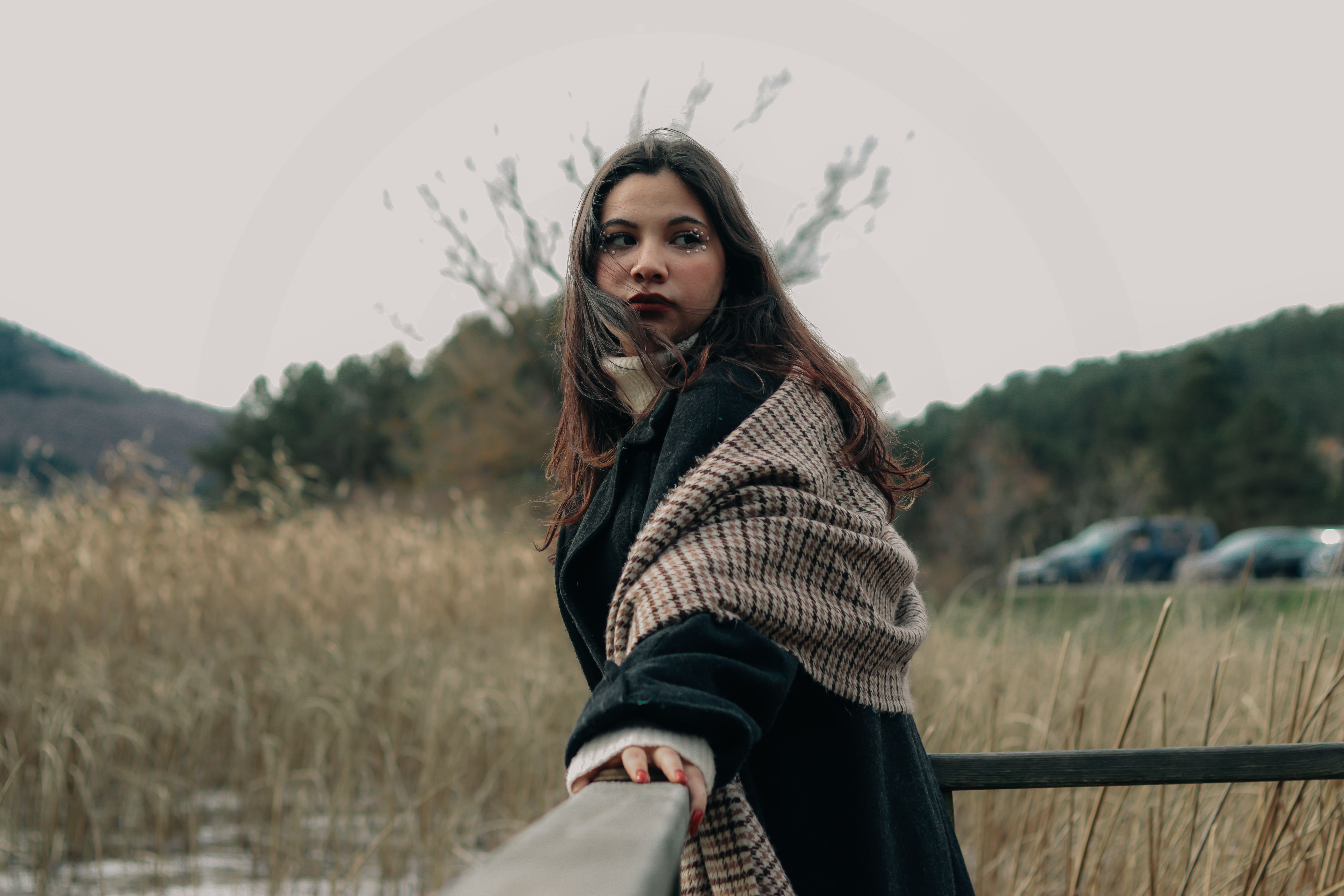 Woman in Large Scarf Standing on Porch Overlooking Field · Free Stock Photo