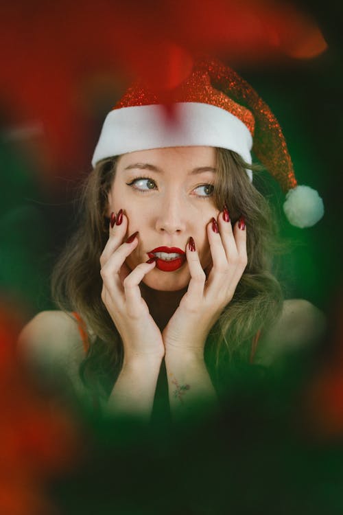 Model in Santa Hat Through Christmas Wreath