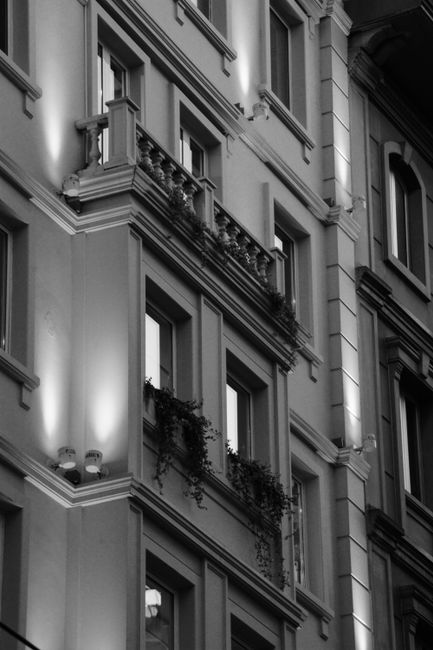Classic townhouse facade in grayscale with balconies and architectural details.