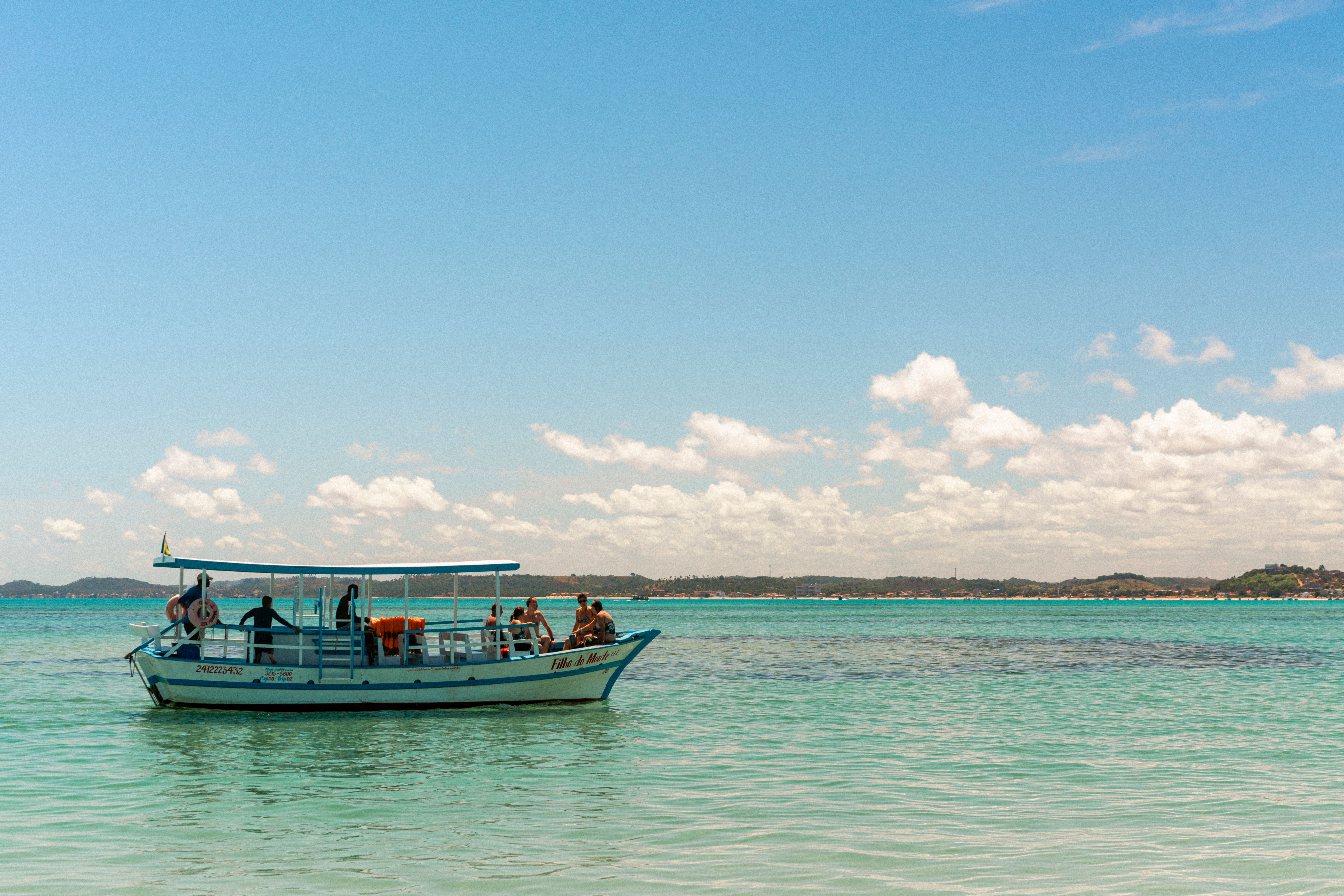 People Sitting on a Boat Riding near the Shore · Free Stock Photo
