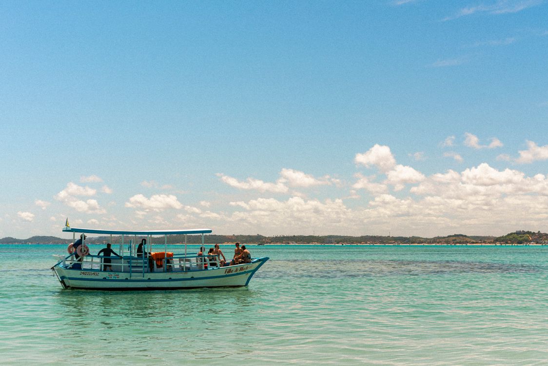 People Sitting on a Boat Riding near the Shore · Free Stock Photo