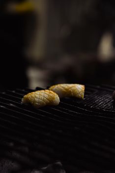 Delicious grilled sushi nigiri pieces sizzling on a barbecue grill, showcasing gourmet cooking.