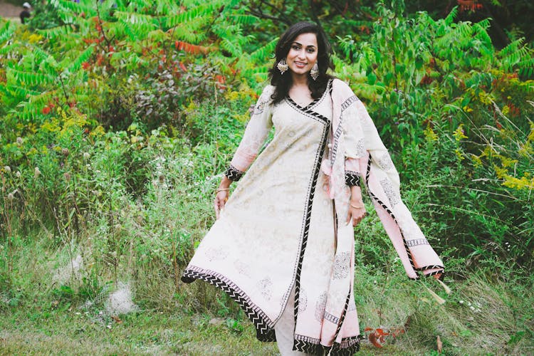 Woman Wearing Traditional Dress In A Garden 