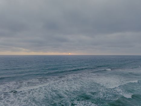 Tranquil dusk view of the ocean waves and cloudy sky in Salinas, Ecuador.