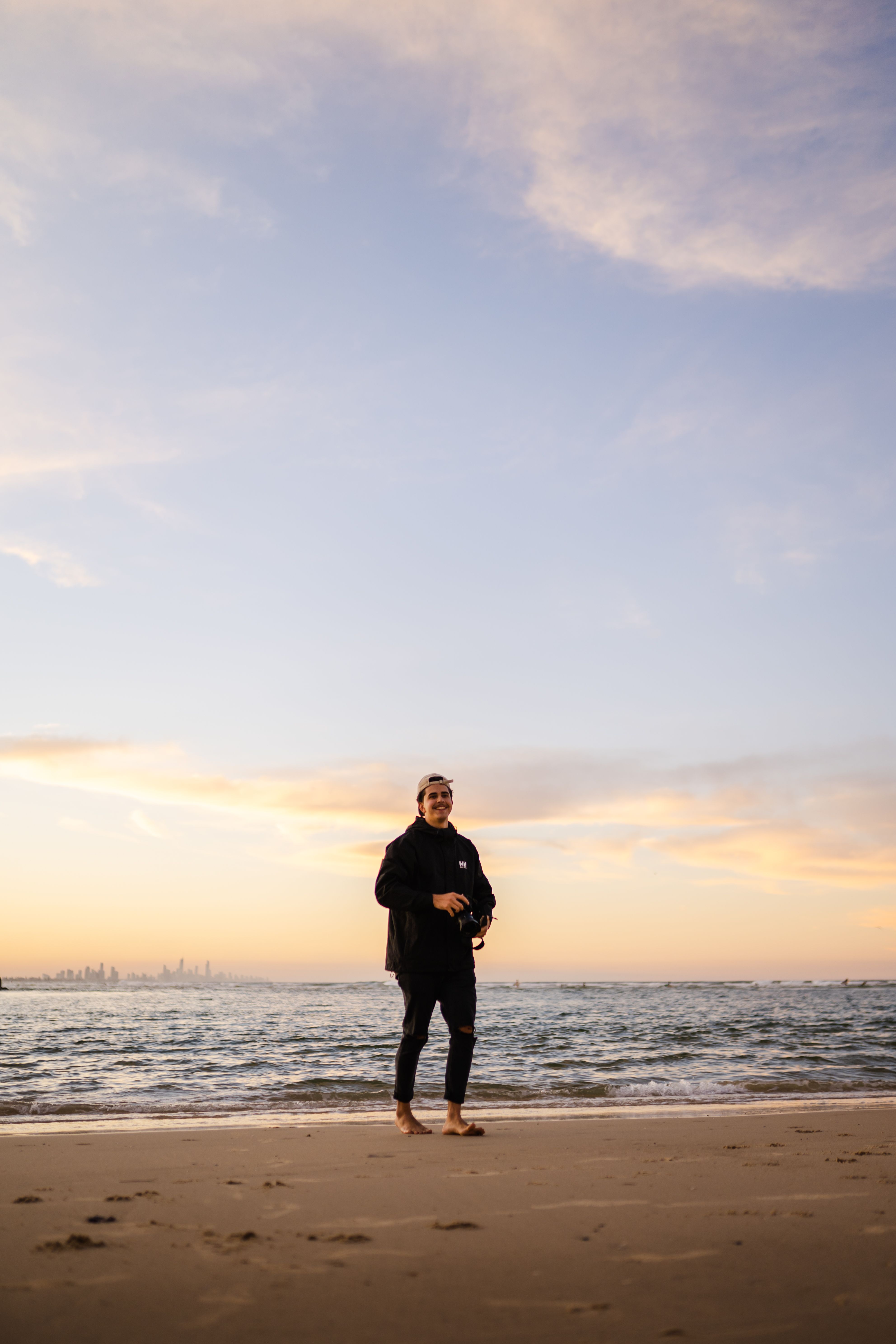 A Man Walking on a Beach at Sunset · Free Stock Photo