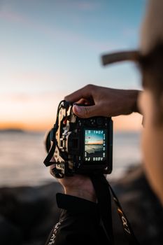 A photographer captures the scenic Gold Coast sunset using a DSLR camera, highlighting artistry and nature.