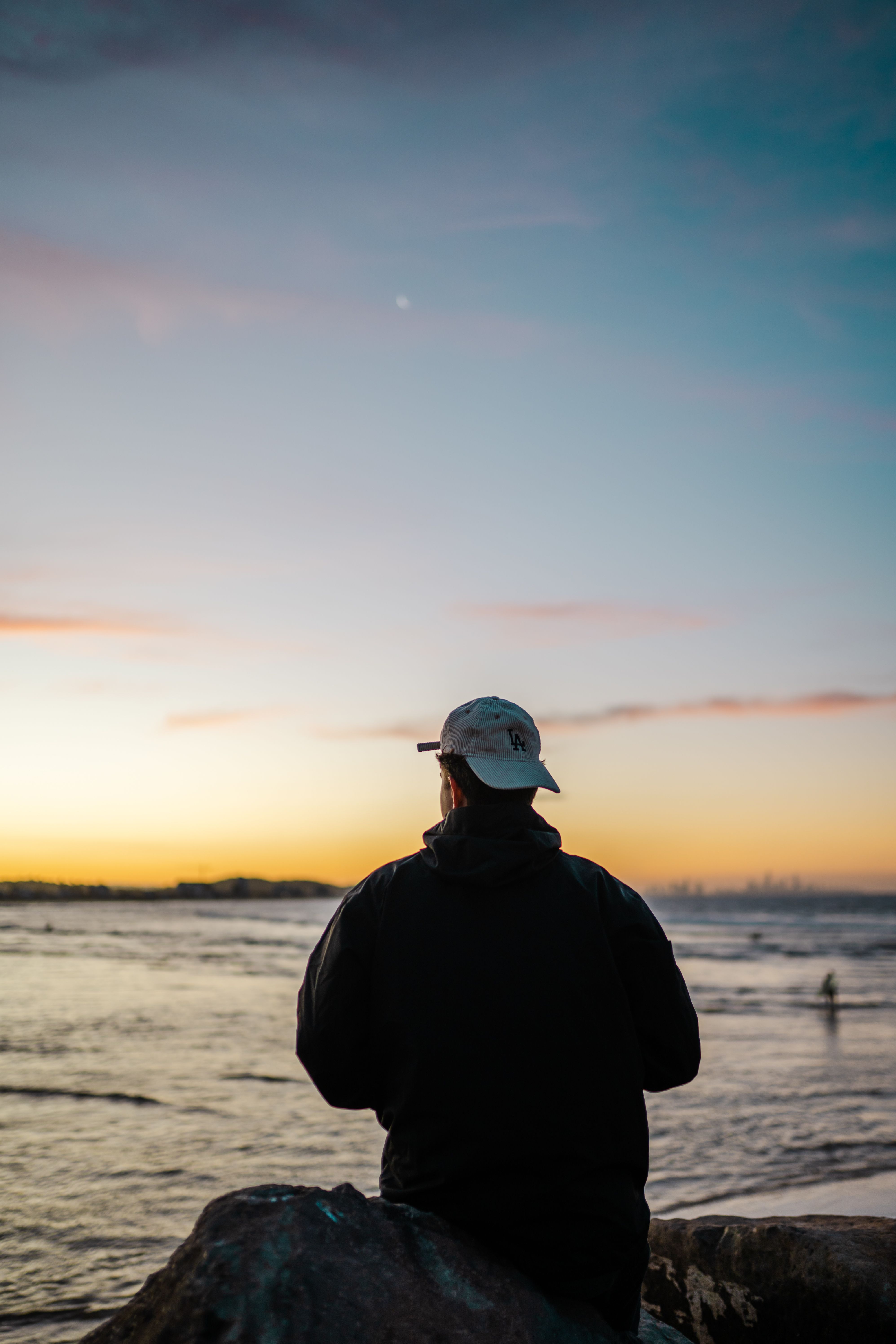 Back View of a Man Standing on a Shore at Sunset · Free Stock Photo